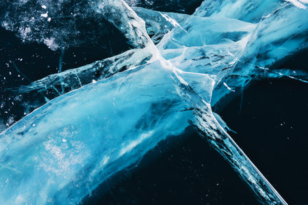 Transparent blue ice with cracks on Baikal lake in winter. Abstract winter nature background.の写真素材