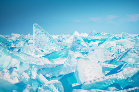 Blue transparent ice floes on Baikal lake at sunset. Selective focus. Baikal, Siberia, Russia. Winter landscapeの写真素材