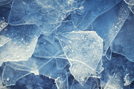 Ice floes with hoarfrost on the frozen lake. Texture of blue ice close up. Abstract winter nature...