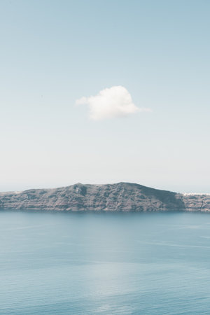 Blue sea and the blue sky with white cloud. View of Thirassia island from Santorini island, Greece. Beautiful summer seascape.の写真素材