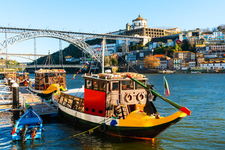 Porto, Portugal. Bridge Ponte Luis I over Douro river. Old traditional boats on the river. View of the old town. Famous travel destinationの写真素材