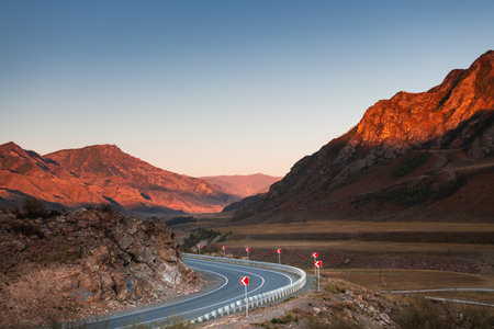 Road in the autumn mountains at sunset. Chuysky tract in Altai, Russia. Beautiful autumn landscapeの写真素材