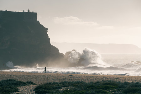 Big ocean waves crashing on the beach in Nazare, Portugal. Beautiful coast of Atlantic ocean at sunsetの写真素材