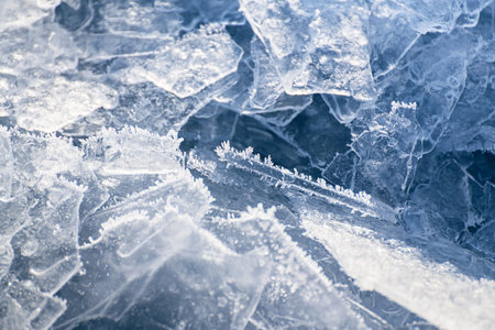 Ice floes with hoarfrost on the frozen lake. Texture of blue ice close up. Abstract winter nature...