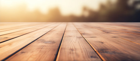 Close-up of a warm-toned wooden deck, softly blurred background of a sunlit landscape.の写真素材