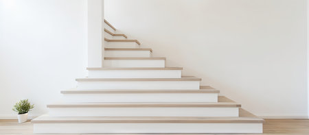 A pristine white wall serves as a backdrop to a stylish wooden staircase, embodying modern minimalist design.の写真素材