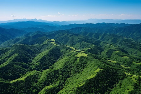 Stunning aerial shot of rolling green mountains under a clear blue sky. The image evokes a sense of serenity and vastnessの写真素材