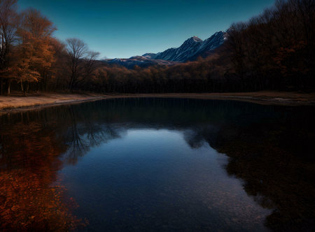 A tranquil autumn lake mirroring majestic snow-capped mountains under a twilight sky.