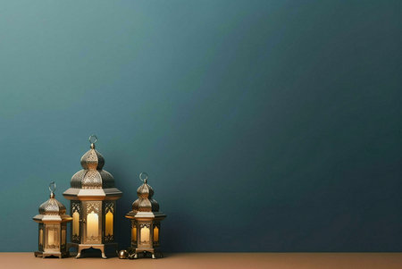 Three golden lanterns with intricate designs stand against a teal wall. The lanterns are lit, casting a warm glow. This image is perfect for celebrating Ramadan, Eid, and other Islamic holidays.の写真素材