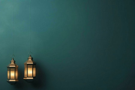 Two lanterns are hanging on a teal wall with soft light coming from the inside