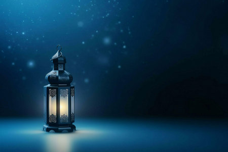 A single ornate lantern with a lit candle inside, set against a dark blue background with subtle sparkling lights, creating a beautiful and symbolic image.の写真素材