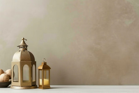 Two golden lanterns on a beige background. The larger lantern has a detailed design and a small...