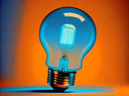 A close-up image of a blue light bulb against an orange background.の写真素材