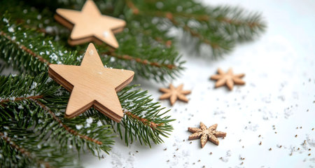 Wooden stars nestled in snowy fir branches. A festive, rustic Christmas image.の写真素材