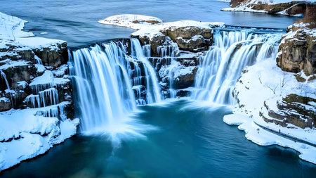 Stunning winter waterfall scene. Frozen cliffs, cascading water, vibrant blue hues.の写真素材