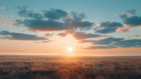 A breathtaking sunset paints the prairie sky with warm hues. Golden grasses stretch to the horizon.の写真素材