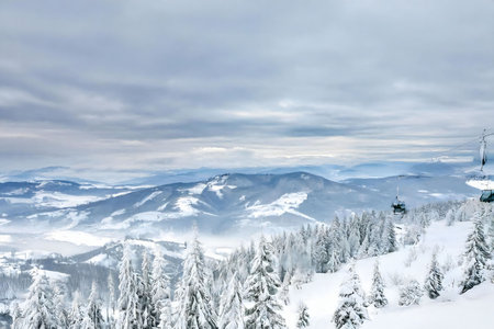 Stunning winter panorama showcasing snow-capped mountains, a ski lift, and a tranquil forest. A breathtaking scene.の写真素材