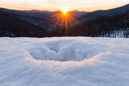 Stunning sunset over snow-covered mountains. Winter wonderland scene.