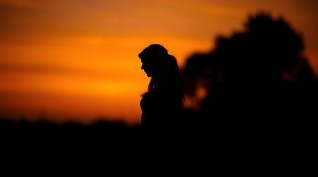 Silhouette of a woman at sunset. Peaceful, serene atmosphere.の写真素材