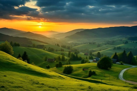 A breathtaking sunset illuminates rolling green hills and distant mountains. The scene is peaceful and sereneの写真素材