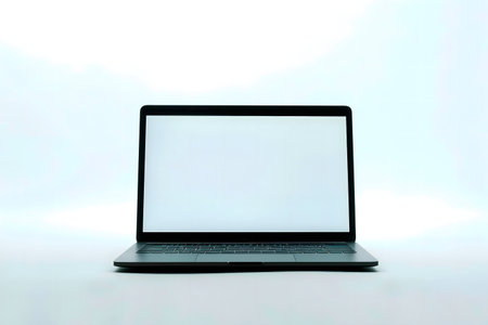 A sleek modern laptop with a blank white screen against a bright white background.の写真素材