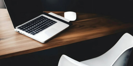 A clean workspace with a laptop on a wooden desk.の写真素材