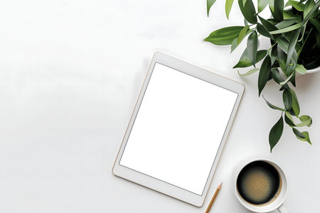 Flatlay of a clean workspace with a tablet, coffee, and plant.