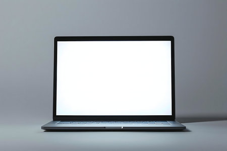 A minimalist image showing a laptop with a blank white screen against a gray backgroundの写真素材
