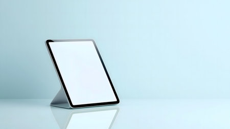 A sleek tablet with a blank screen on a light blue background. Perfect for showcasing apps or designs.の写真素材