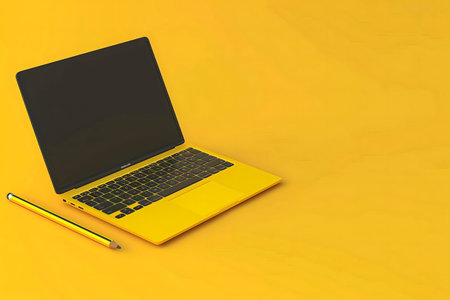 A yellow laptop and a pencil on a yellow background. Minimalist, simple, and modern.の写真素材