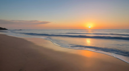 Peaceful sunrise over a tranquil beach. Golden hour light illuminates the sand and waves.の写真素材