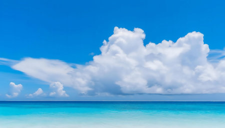 Stunning summer seascape, azure waters meet fluffy clouds under a bright blue sky.の写真素材