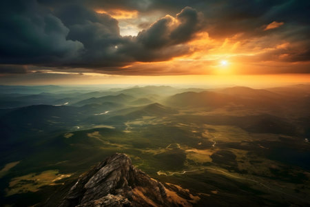 Breathtaking sunset view from a mountaintop, showcasing vast mountain ranges bathed in golden light.の写真素材