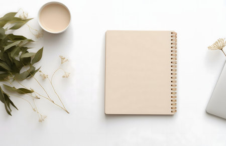 A flatlay image featuring a beige notebook, dried flowers, and a cup of coffee on a white background. Clean and minimalist aesthetic.の写真素材