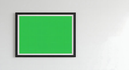 A single green artwork in a black frame hangs on a white wall. Minimalist and stylish.の写真素材