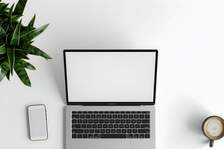 A clean, minimalist workspace featuring a laptop, smartphone, a potted plant, and a cup of coffee. Perfect for productivity.の写真素材