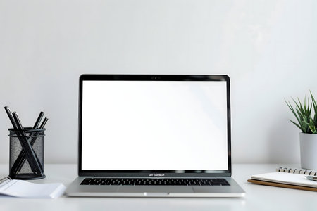 Clean workspace with laptop, notebook, and plantの写真素材