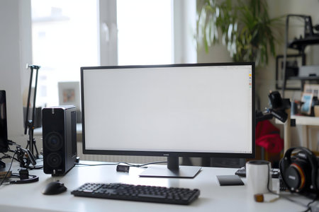 A clean and minimalist workspace featuring a large monitor, computer, keyboard, and other...