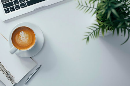 A serene workspace featuring a latte, laptop, and plant. Perfect for productivity and relaxation.