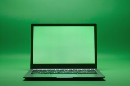 Laptop on green background. Minimalist tech imageの写真素材
