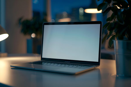 Laptop on a desk at night, blank screen.
