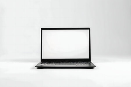 A black laptop with a blank screen sits on a clean white background. Minimalist technology.の写真素材