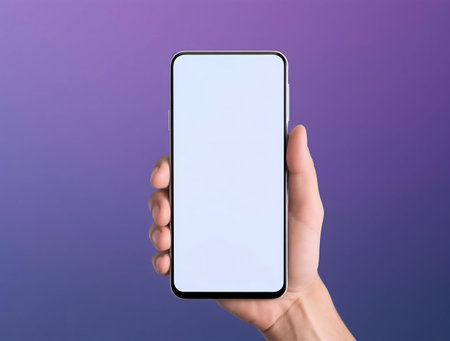 A hand holding a smartphone with a blank white screen against a purple backdrop.の写真素材