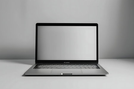A sleek silver laptop sits on a clean white desk against a light gray background.