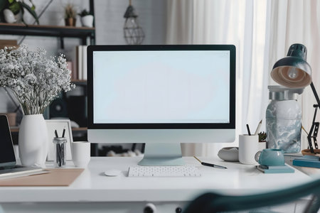 Stylish home office with a computer, plants, and accessories. The blank screen offers space for your...