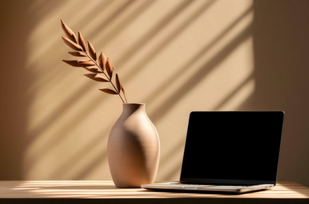 A peaceful workspace featuring a laptop and a beige vase.