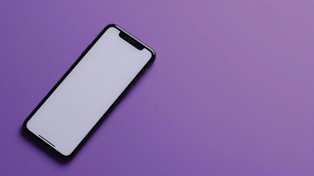 A black smartphone with a blank white screen rests on a purple background. Minimalist technology concept.の写真素材
