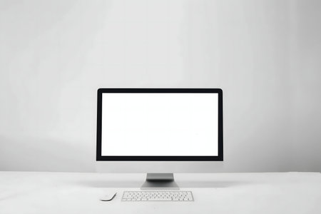 A clean, minimalist workspace featuring a computer with a blank screen, keyboard, and mouse on a...
