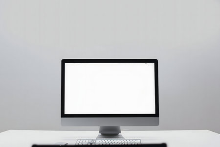Close up of computer with blank screen on white desk and gray backgroundの写真素材
