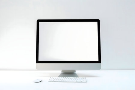 A pristine white desk showcases a sleek computer setup, minimalist and modern.
